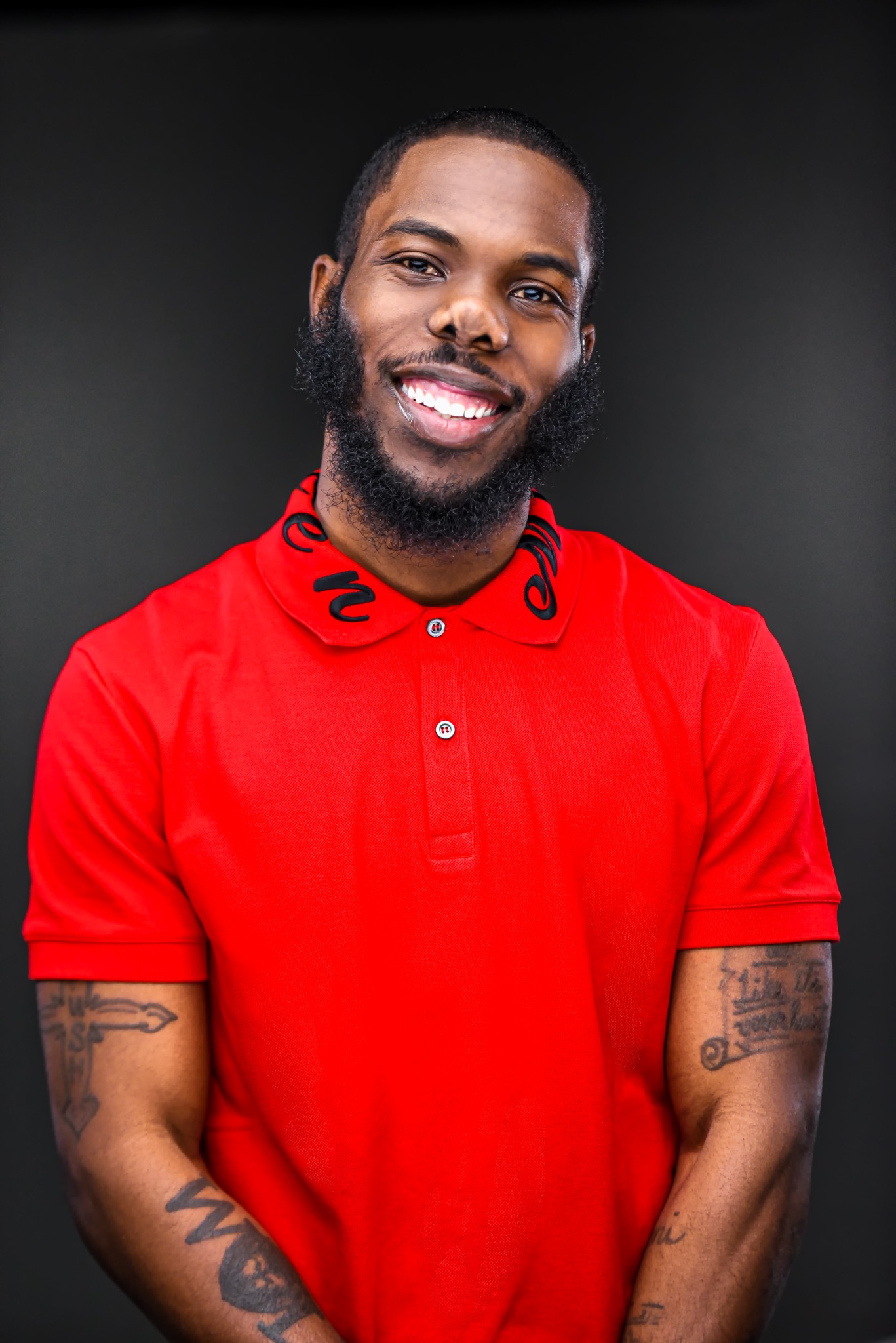 Naiym Wolf smiling in a red shirt